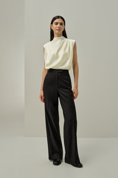 Ivory satin sleeveless draped blouse with high neckline and gathered folds