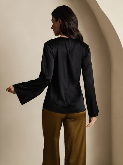 Black satin blouse from the back with long flare sleeves and rounded neckline.