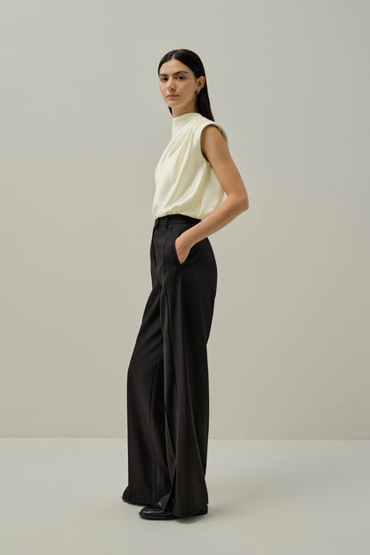 Ivory satin sleeveless draped blouse with high neckline and flowing drape