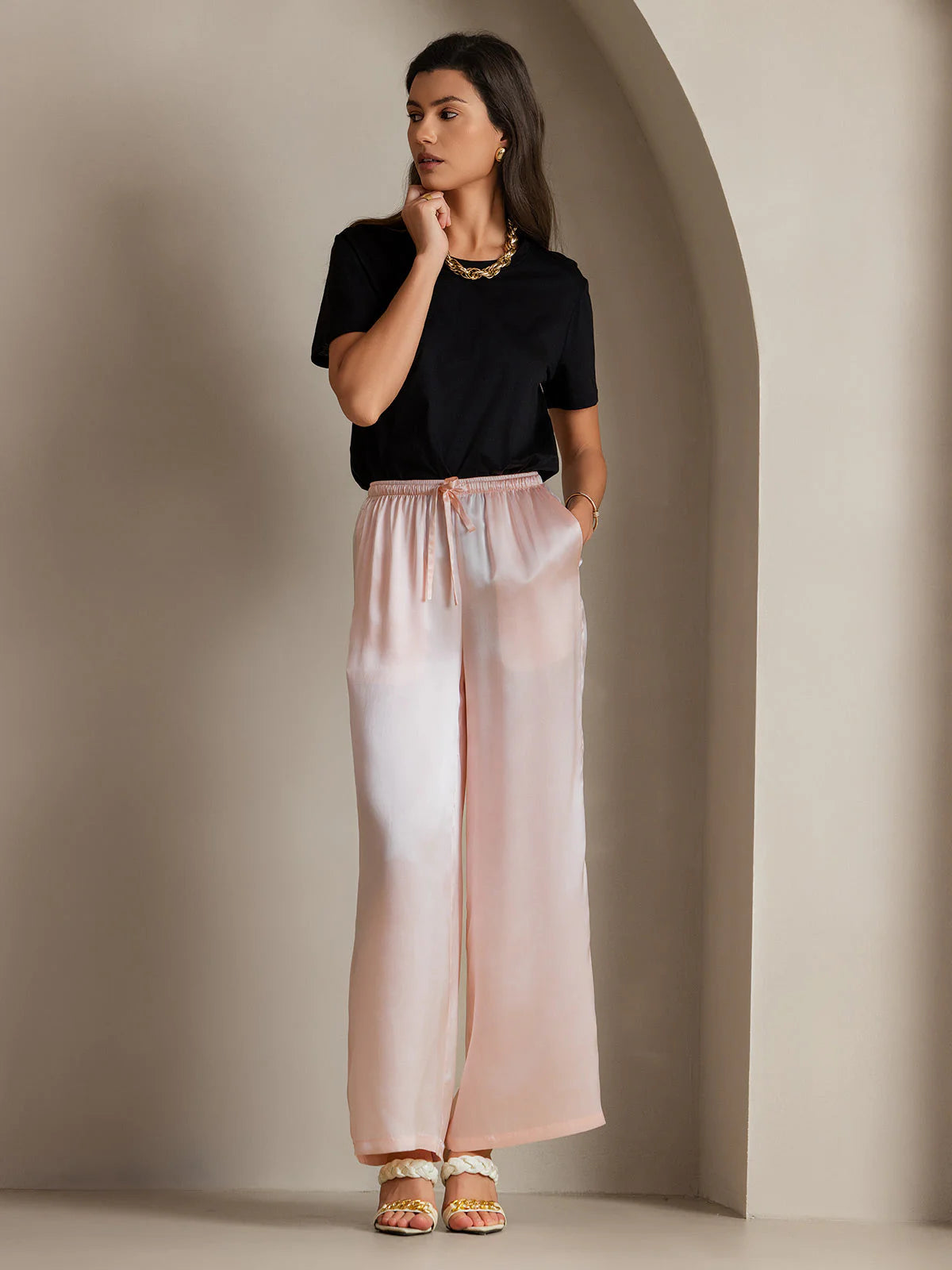 Pink silk wide-leg pants with elastic waistband and drawstring ties, draped fit