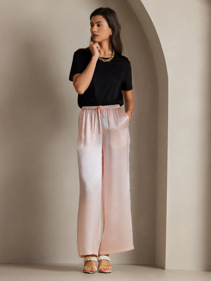 Pink silk wide-leg pants with elastic waistband and drawstring ties, draped fit