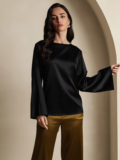 Black satin blouse with round neckline and dramatic flare sleeves.