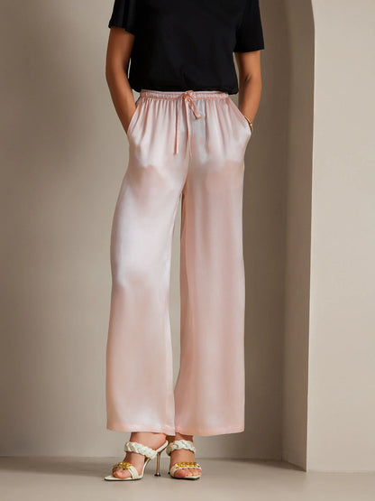 Pink silk relaxed pants with elastic drawstring waist and wide, flowy legs