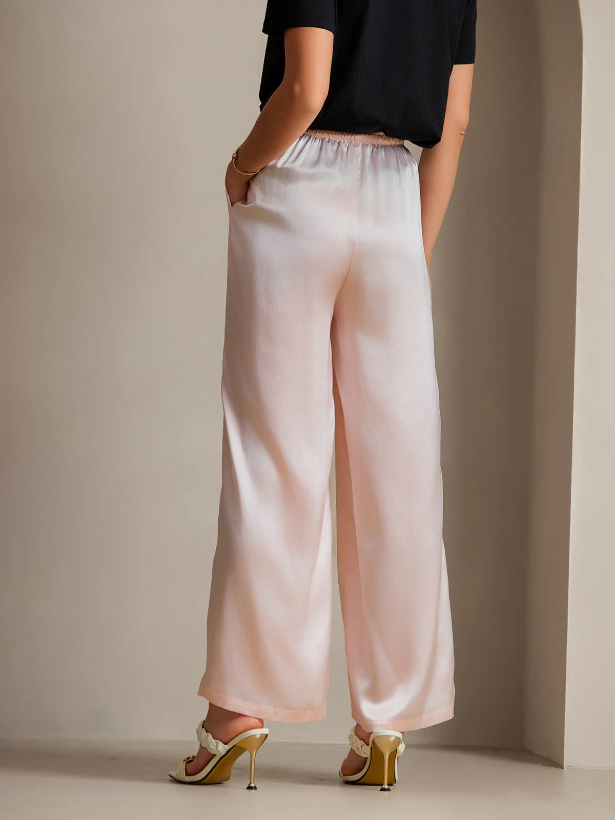 Pink silk relaxed pants with wide legs and elastic waist with drawstring ties