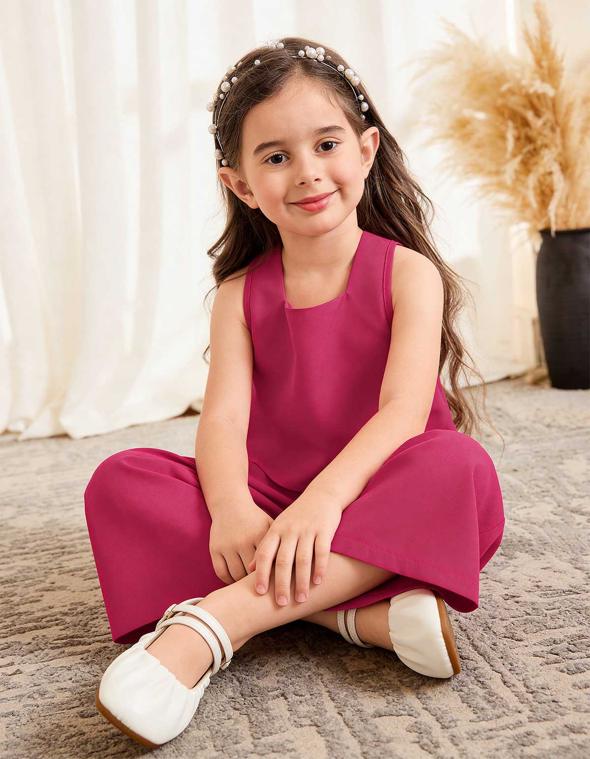 Girls magenta sleeveless square-neck top and wide-leg pants, seated with headband