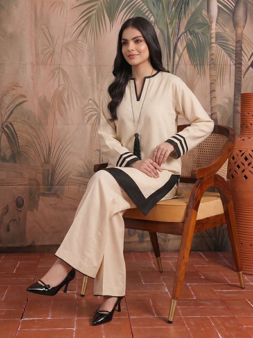 Cream long tunic with black chevron hem, striped cuffs, styled with wide-leg pants