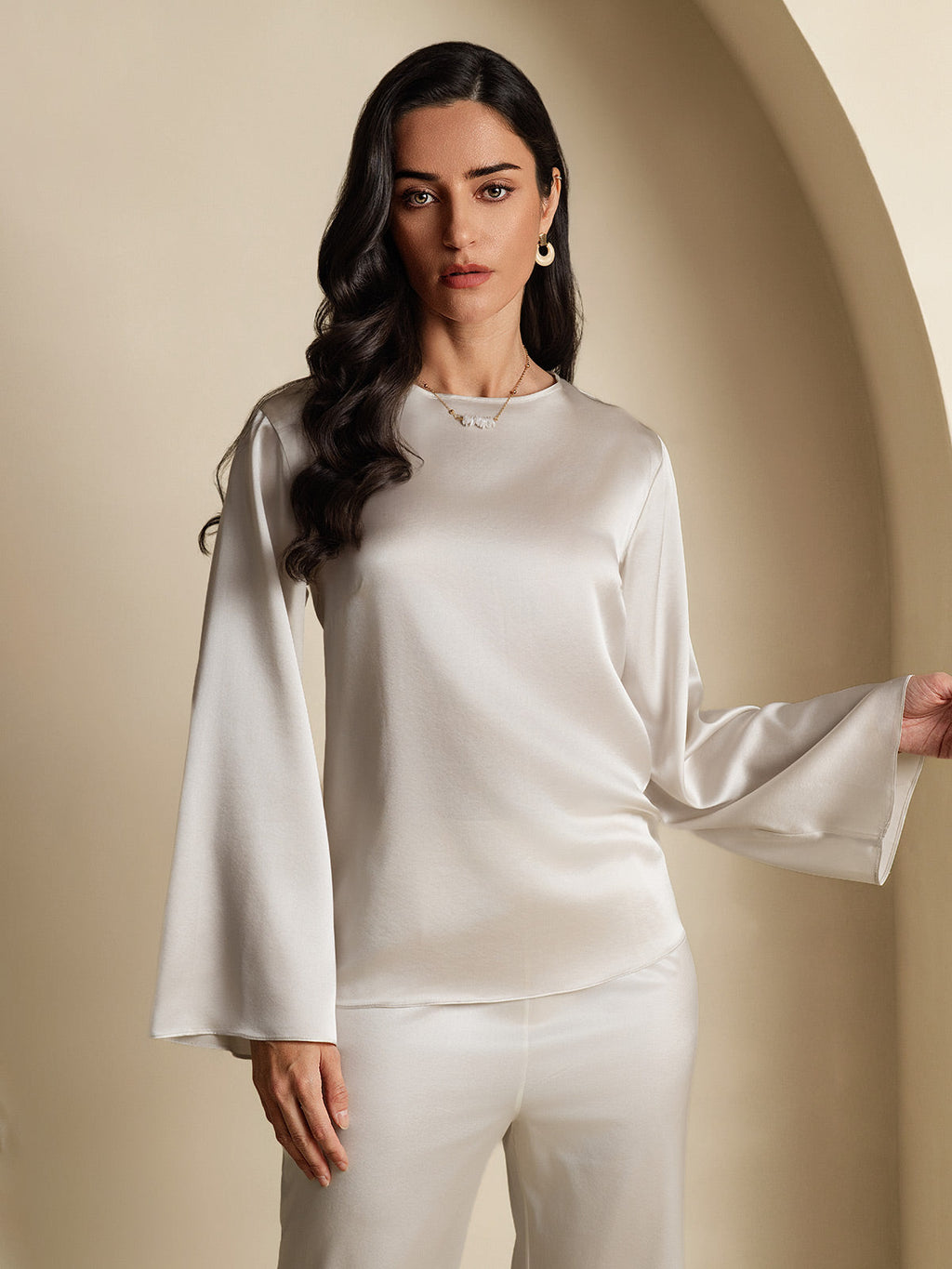 Satin long-sleeve blouse with high neckline and flared sleeves, draped front view