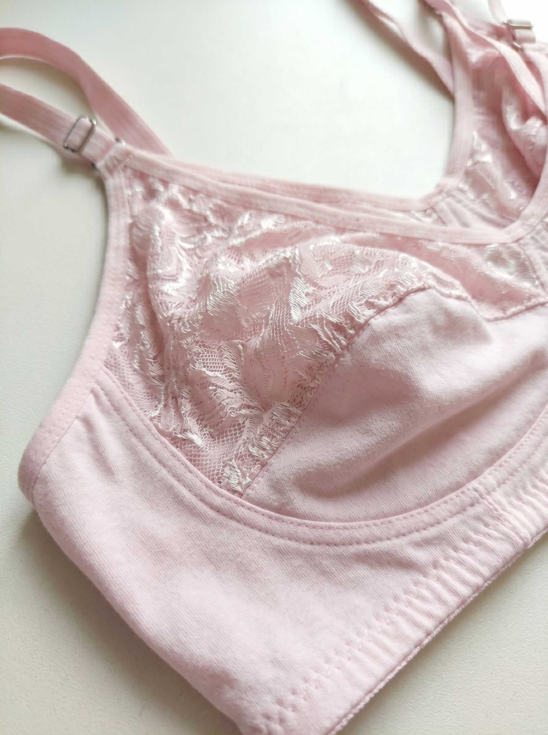 Pink lace wire-free bra close-up with textured cups and adjustable strap