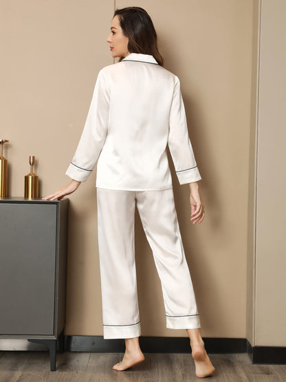 White pajama set, button-up shirt and straight-leg pants with contrast piping along cuffs
